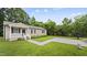 Charming single-story home with a well-maintained lawn, concrete driveway, and lush surrounding trees at 427 Elm Ct, Burlington, NC 27217