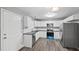 Bright kitchen with white cabinets, stainless steel appliances, and modern backsplash at 427 Elm Ct, Burlington, NC 27217