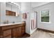 Bright bathroom features a wood vanity, shower, and a window providing natural light at 4703 Pleasant Green Rd, Durham, NC 27705