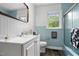 This bathroom features turquoise tile, wood floors, a shower/tub, and white wainscotting at 4703 Pleasant Green Rd, Durham, NC 27705