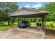 Carport for covered parking with a blue truck and two trashcans at 4703 Pleasant Green Rd, Durham, NC 27705