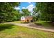 Brick house exterior featuring a long driveway and green lawn on a lush, wooded lot at 4703 Pleasant Green Rd, Durham, NC 27705