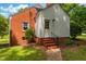 A back entrance of a brick and vinyl sided house with stairs leading to the back door at 4703 Pleasant Green Rd, Durham, NC 27705