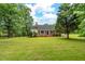 Spacious front yard with mature trees and a charming brick home at 4703 Pleasant Green Rd, Durham, NC 27705