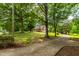 Brick home nestled within a sprawling, grassy lawn and mature trees, long driveway at 4703 Pleasant Green Rd, Durham, NC 27705