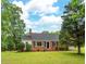 Charming brick ranch-style home with a welcoming front yard and mature trees offering shade at 4703 Pleasant Green Rd, Durham, NC 27705
