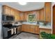 Kitchen featuring stainless steel appliances, wood cabinets, tile backsplash, and a bright window overlooking the yard at 4703 Pleasant Green Rd, Durham, NC 27705
