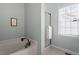 Bathroom featuring a soaking tub, glass enclosed shower, and a bright window at 500 Weaver Mine Trl, Chapel Hill, NC 27517