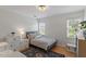 Well-lit bedroom with hardwood floors, two windows, and neutral-colored walls at 500 Weaver Mine Trl, Chapel Hill, NC 27517