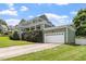 Green two-story home with a manicured lawn, a two-car garage, and a long driveway at 500 Weaver Mine Trl, Chapel Hill, NC 27517