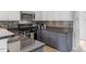 Well-lit kitchen featuring stainless steel appliances, mosaic tile backsplash, and gray cabinets at 500 Weaver Mine Trl, Chapel Hill, NC 27517