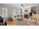 Bright living room with a fireplace, large windows, hardwood floors and neutral decor at 500 Weaver Mine Trl, Chapel Hill, NC 27517