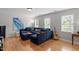 Cozy living room showcasing hardwood floors, a large blue sectional sofa, and bright natural light at 500 Weaver Mine Trl, Chapel Hill, NC 27517