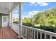 Inviting porch with white columns, wooden floors, and a view of lush greenery and blue skies at 500 Weaver Mine Trl, Chapel Hill, NC 27517