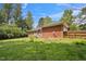 The home boasts a sprawling backyard with a wooden fence, beautiful landscaping, and mature trees at 5405 Doemont Dr, Apex, NC 27539