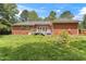 Backyard view of home showing wooden deck with stairs, fenced in yard, and mature trees at 5405 Doemont Dr, Apex, NC 27539