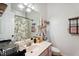 Well-appointed bathroom with a floral shower curtain, sink vanity, and storage shelves at 5405 Doemont Dr, Apex, NC 27539