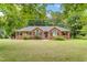 Lovely brick home with arched windows, black shutters, and a well-maintained lawn at 5405 Doemont Dr, Apex, NC 27539