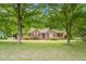 Charming brick home featuring a well-manicured lawn and beautiful mature trees offering shade at 5405 Doemont Dr, Apex, NC 27539