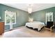 Comfortable main bedroom features neutral carpet, a chandelier, and natural light from two windows at 5405 Doemont Dr, Apex, NC 27539