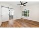 Primary bedroom featuring a barn door, vaulted ceilings, wood flooring, and a large window at 5428 Passenger Pl, Raleigh, NC 27603