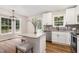 Eat-in kitchen featuring white cabinets, granite counters, an island with seating, and natural light at 5428 Passenger Pl, Raleigh, NC 27603