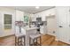 Bright eat-in kitchen with white cabinets, stainless appliances, granite countertops, and wood flooring at 5428 Passenger Pl, Raleigh, NC 27603