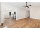 Open-concept living room with modern ceiling fan that connects to a bright kitchen with a breakfast bar at 5428 Passenger Pl, Raleigh, NC 27603