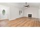 Open-concept floor plan living room featuring a modern fireplace, ceiling fan and gorgeous floors at 5428 Passenger Pl, Raleigh, NC 27603