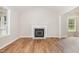 Spacious living room with hardwood floors, a cozy fireplace, and large windows providing ample natural light at 5428 Passenger Pl, Raleigh, NC 27603