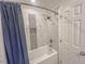 Bathroom featuring a tub with blue shower curtains and tiled walls at 5500 Fortunes Ridge Dr # 94C, Durham, NC 27713