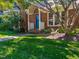 Inviting brick townhome featuring a covered porch, beautiful landscaping, and a welcoming front door at 5500 Fortunes Ridge Dr # 94C, Durham, NC 27713
