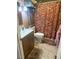 Bathroom with a floral shower curtain, wood vanity and a stack of towels at 56 Sugarhill Dr, Zebulon, NC 27597