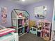 Bright bedroom with a purple accent wall, filled with toys and dollhouses, creating a playful atmosphere at 56 Sugarhill Dr, Zebulon, NC 27597