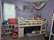 Cozy bedroom featuring a loft bed, playful decor, and ample storage space with a purple accent wall at 56 Sugarhill Dr, Zebulon, NC 27597