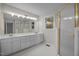 Bathroom with dual vanity sinks, gold-trimmed mirrors and a glass-enclosed shower at 6001 Waters Way Dr, Raleigh, NC 27606