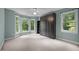 This bedroom features a large murphy bed, lots of windows, and light blue walls at 6001 Waters Way Dr, Raleigh, NC 27606