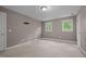 Cozy bedroom featuring neutral carpet, two windows, and an interior door at 6001 Waters Way Dr, Raleigh, NC 27606