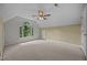 Bedroom featuring neutral carpet, a ceiling fan, and arched window overlooking the yard at 6001 Waters Way Dr, Raleigh, NC 27606