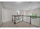 Spacious hallway overlooking a staircase with white railings and black trim at 6001 Waters Way Dr, Raleigh, NC 27606