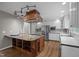 Open kitchen with a custom island, stainless appliances, white cabinets and hardwood floors at 6001 Waters Way Dr, Raleigh, NC 27606