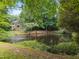 Scenic view of house nestled in trees with a pond on the property at 6001 Waters Way Dr, Raleigh, NC 27606