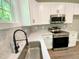 A well-appointed kitchen featuring white cabinets, quartz countertops and stainless steel appliances at 608 A E Umstead, Durham, NC 27701