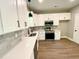 A modern kitchen featuring white cabinets, quartz countertops, and stainless steel appliances at 608 A E Umstead, Durham, NC 27701