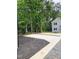 A parking area with both gravel and mulch leading to a home with black trim and a blue front door at 608 A E Umstead, Durham, NC 27701