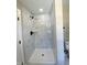 Modern shower featuring black shower head and white marbled tile surround at 608 A E Umstead, Durham, NC 27701