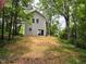 Rear view of a two story home with gray siding, a sliding glass door, and a large yard at 608 E Umstead St, Durham, NC 27701