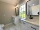 Bathroom with marble-look tile floors, double vanity, white cabinetry, and modern black fixtures at 608 E Umstead St, Durham, NC 27701