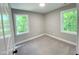 Bedroom with neutral paint, plush carpet, and windows that offer views of a green landscape at 608 E Umstead St, Durham, NC 27701