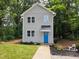 Charming two-story home featuring a bright blue front door, complemented by manicured landscaping and lush trees at 608 E Umstead St, Durham, NC 27701